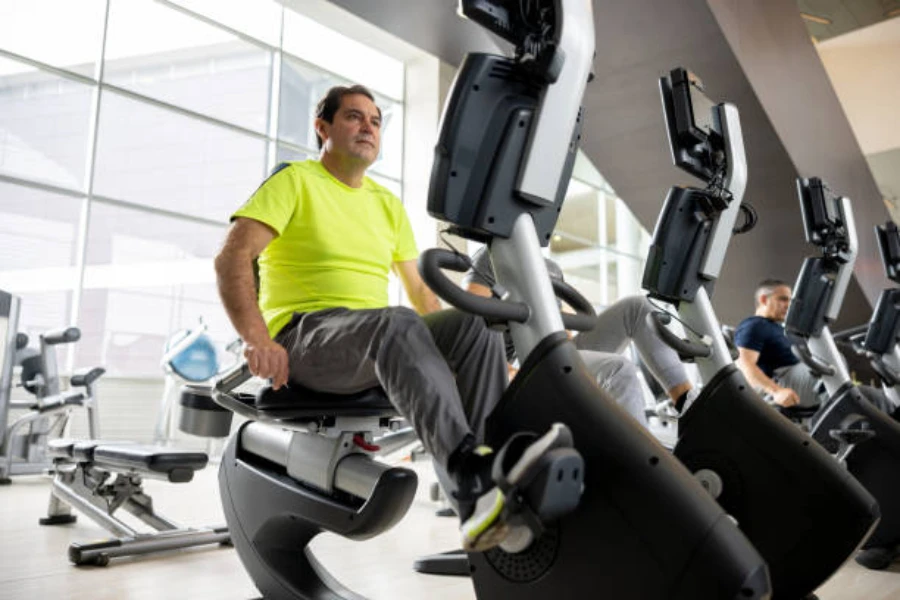 Man using a recumbent bike in a large gym space