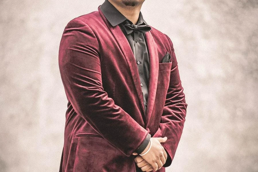 Homem vestindo um blazer de veludo vermelho escuro