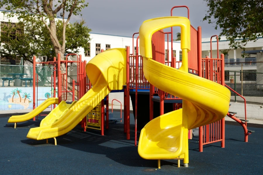 Toboganes infantiles multicolores con piscina seca con gran cantidad de  bolas. patio de juegos vacío