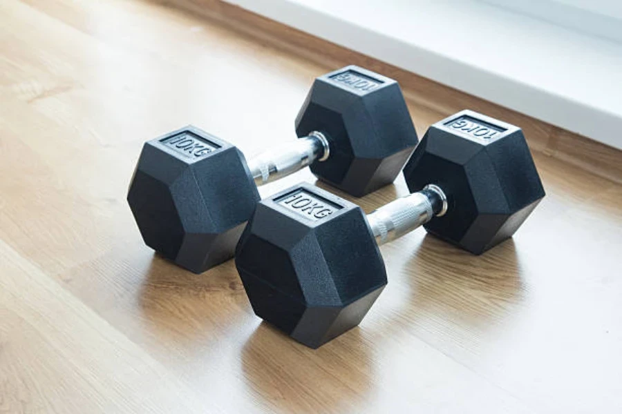 Pair of hexagonal dumbbells sitting on light wood floor