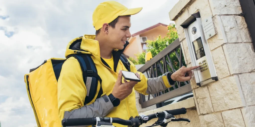 Person pressing a video doorbell to delivery groceries