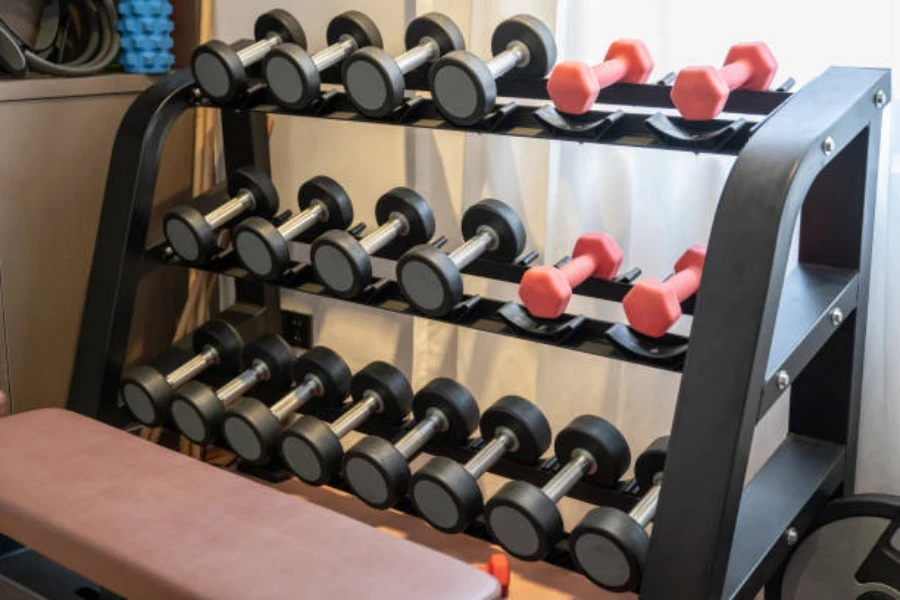 Rack of different weights of dumbbells inside small room