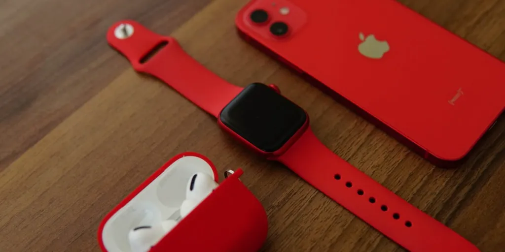 red apple watch, airpods and iphone close up shot