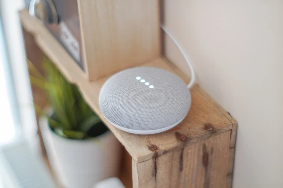 Round gray voice control speaker on a brown shelf