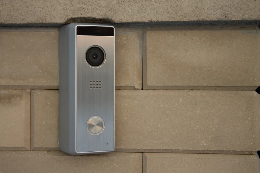 Silver video doorbell installed on a brick wall