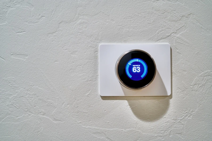 thermostat intelligent sur un mur blanc affichant une température de 63f