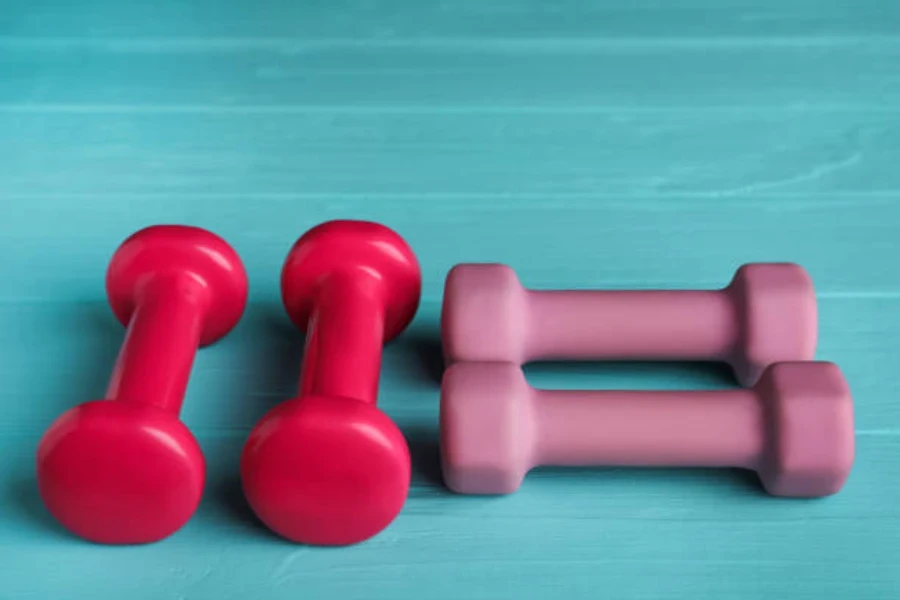 Two sets of light rubber dumbbells on bright blue floor