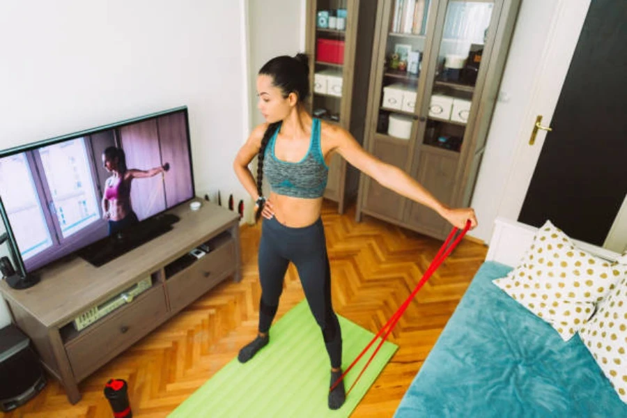 Mulher fazendo exercícios em casa com faixa de resistência longa