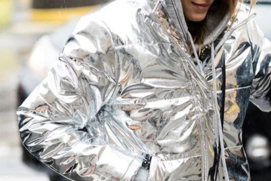 Femme vêtue d'un manteau à capuche métallique brillant