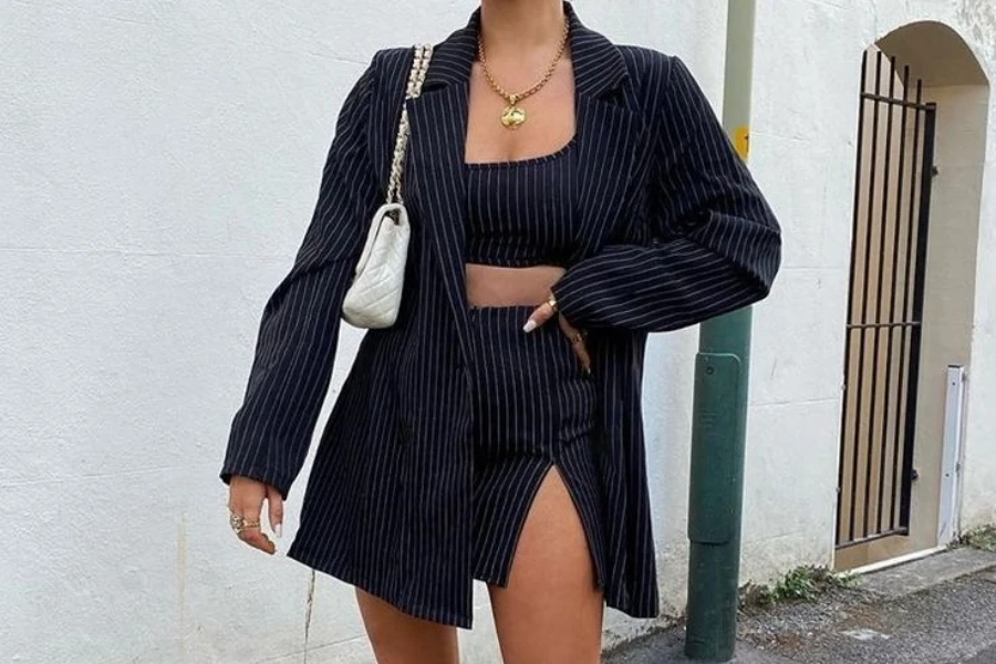 Woman posing stylishly in a striped preppy blazer matching set
