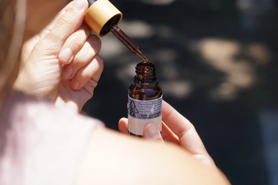 Mujer preparando aceite para cutículas para su uso.