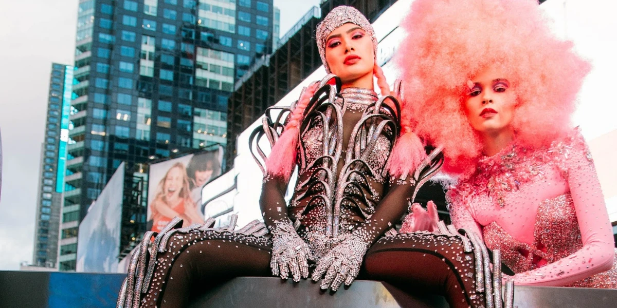 Woman sitting on a platform wearing a glam rock outfit