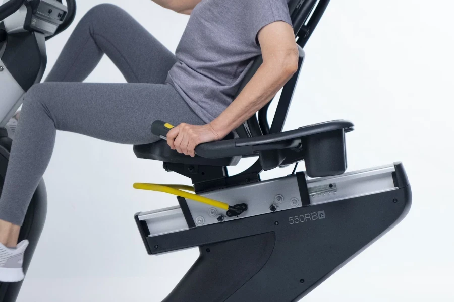 Woman sitting on recumbent bike wearing gray exercise gear