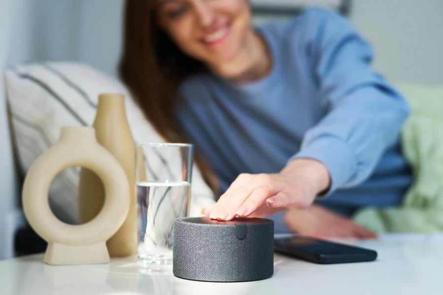 Woman turning on alarm clock on smart speaker