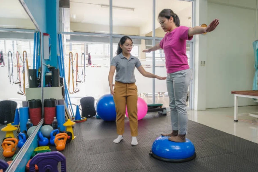 Mujer usando una pelota de equilibrio con fines de rehabilitación