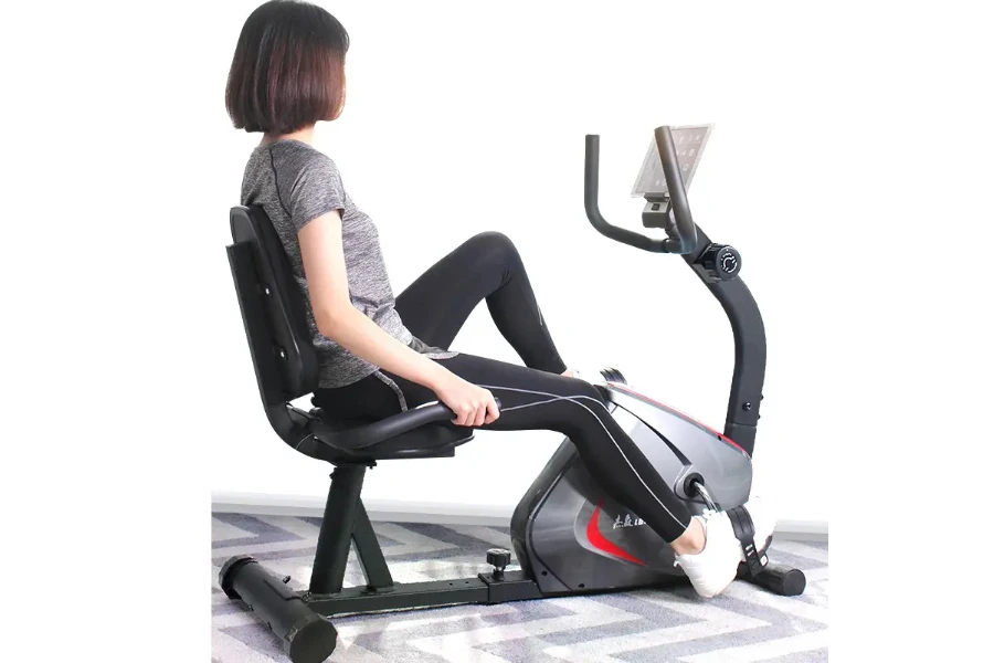 Woman using a semi-recumbent exercise bike in her home