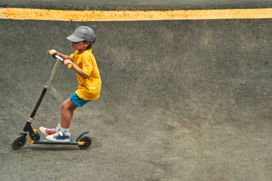 Young boy playing in skate park with a scooter