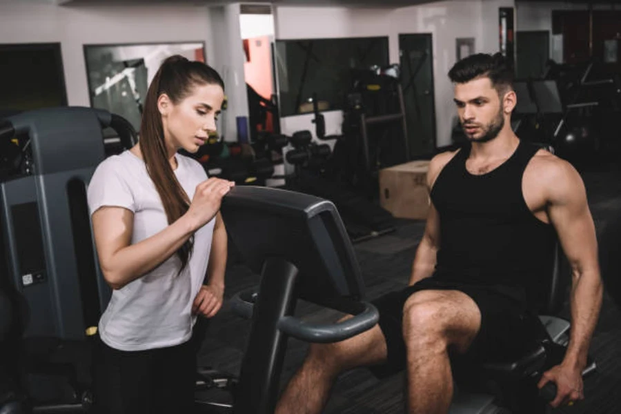 Jüngerer Mann benutzt ein schwarzes Liegerad im Fitnessstudio