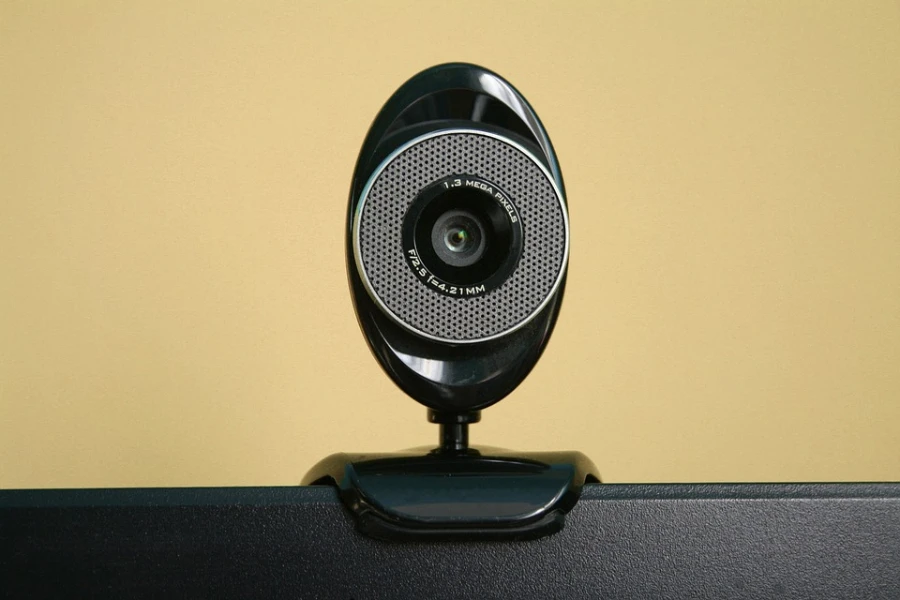 Uma webcam preta fixada em um laptop