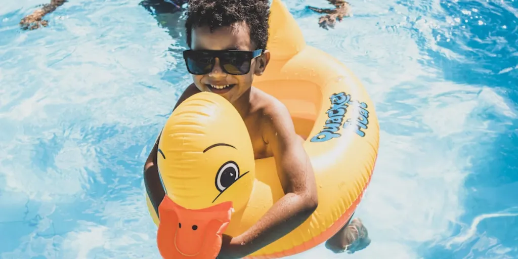 A boy using a pool float in a swimming pool