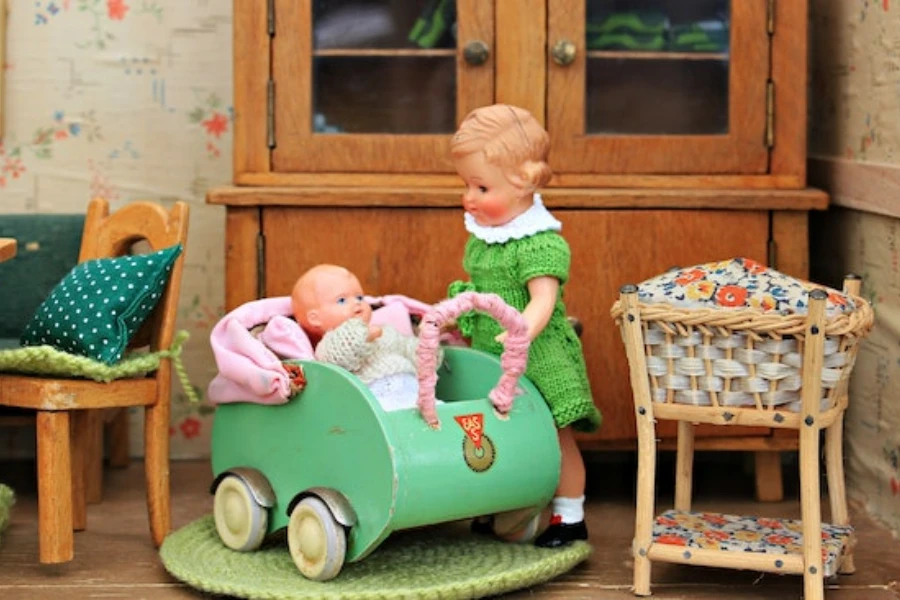 A doll holding another doll’s bassinet