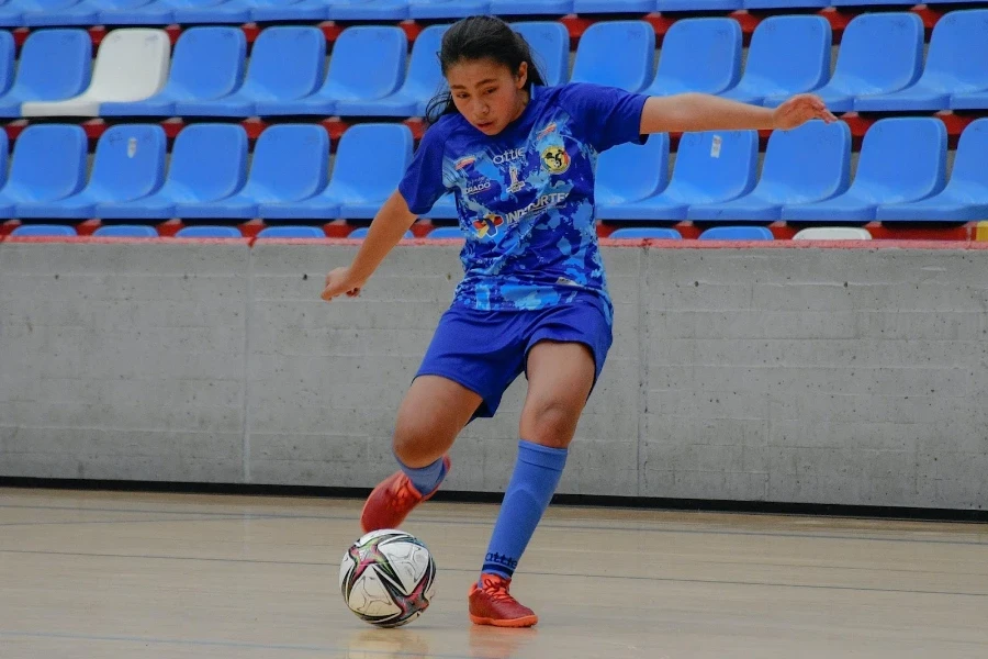 A futsal player kicking a futsal ball