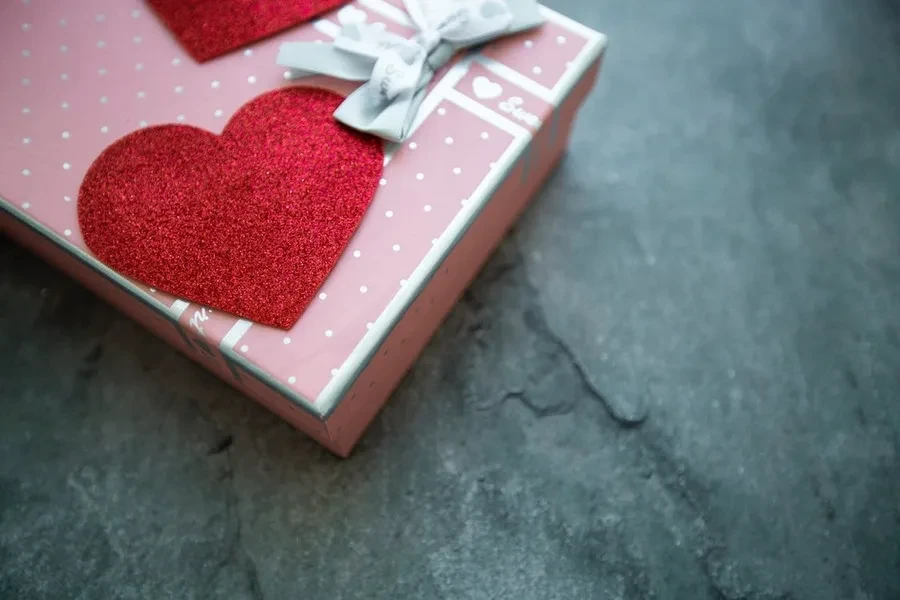 Una caja de regalo decorada con un corazón rojo.