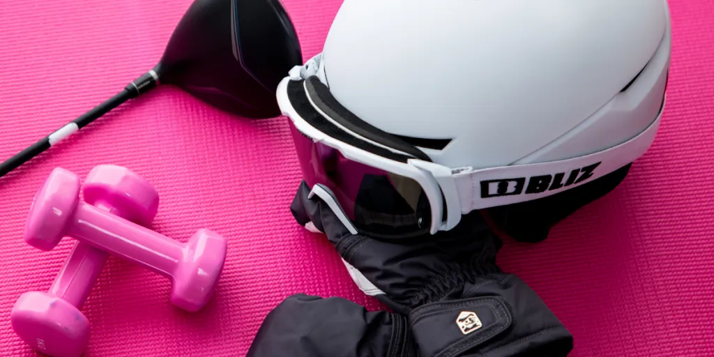 a helmet, gloves, and other gear on a pink background