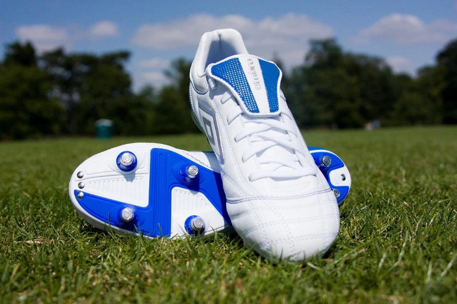 A pair of blue and white cleats on a grass field