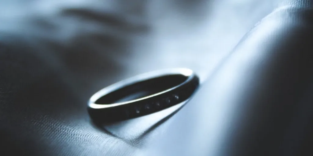 A sleek smart ring on a blue surface