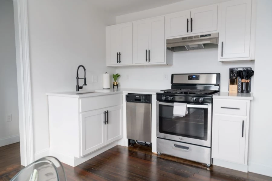 A white kitchen with stove and dishwasher