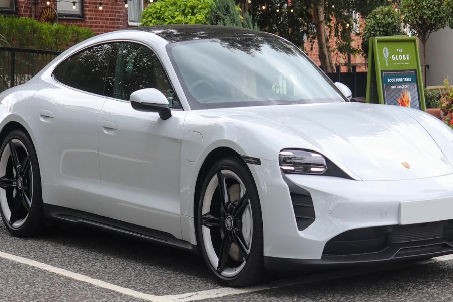 A white Porsche Taycan fitted with the J1 platform