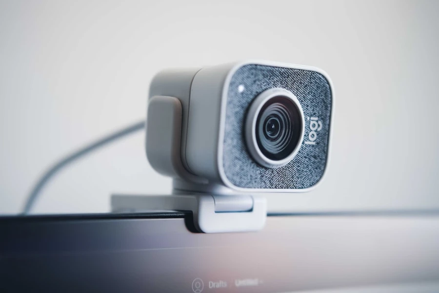 A white wired webcam on a laptop