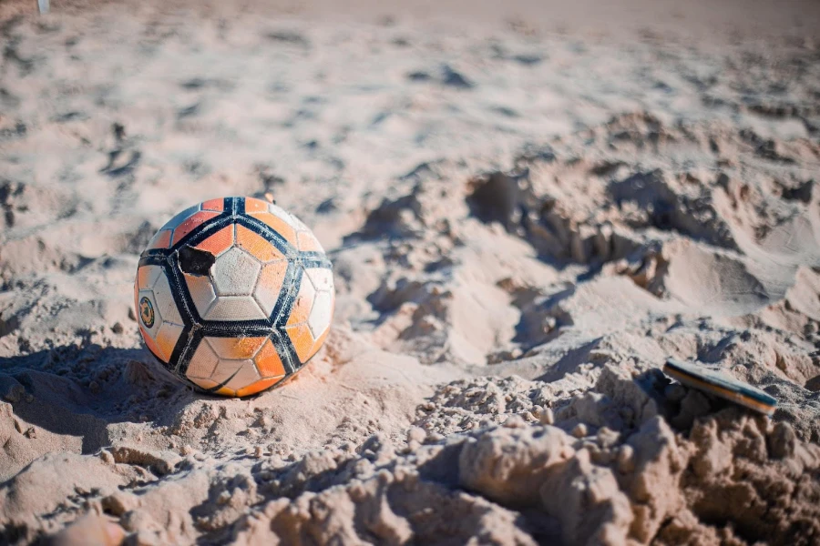 A worn-out beach soccer ball on sand
