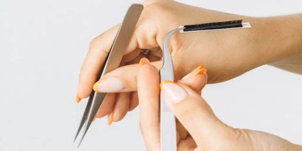 Anonymous person grabbing eyelashes with tweezers