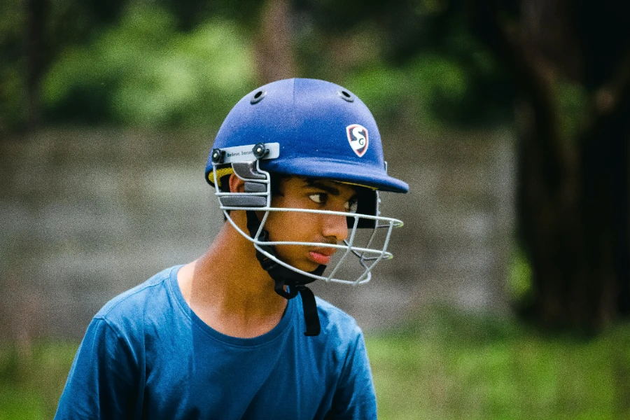 Junge trägt einen blauen Rugby-Helm und ein T-Shirt