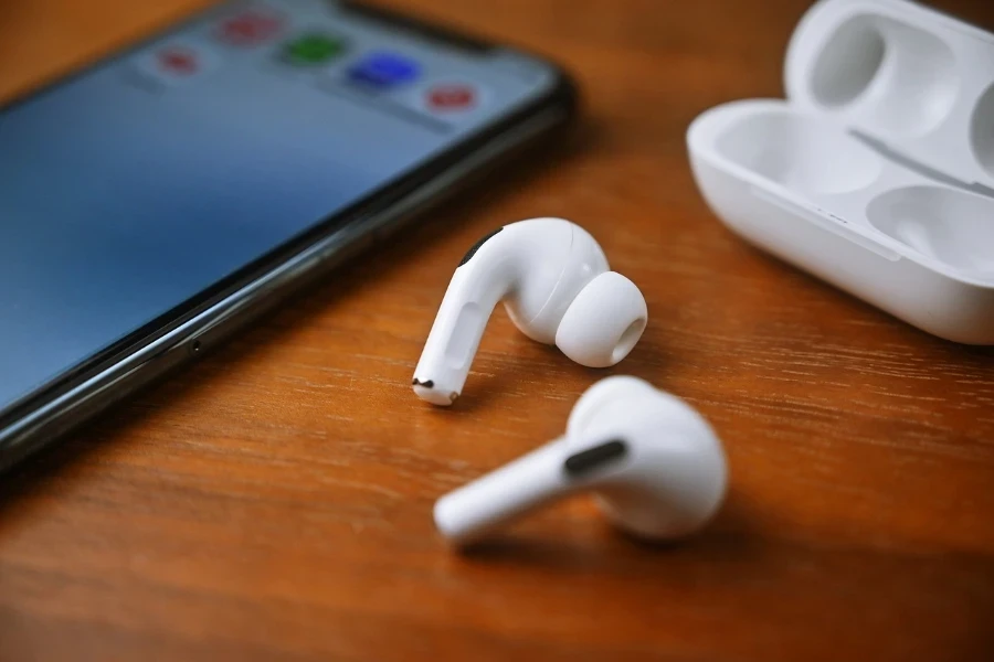 Earbud di luar casingnya di samping ponsel