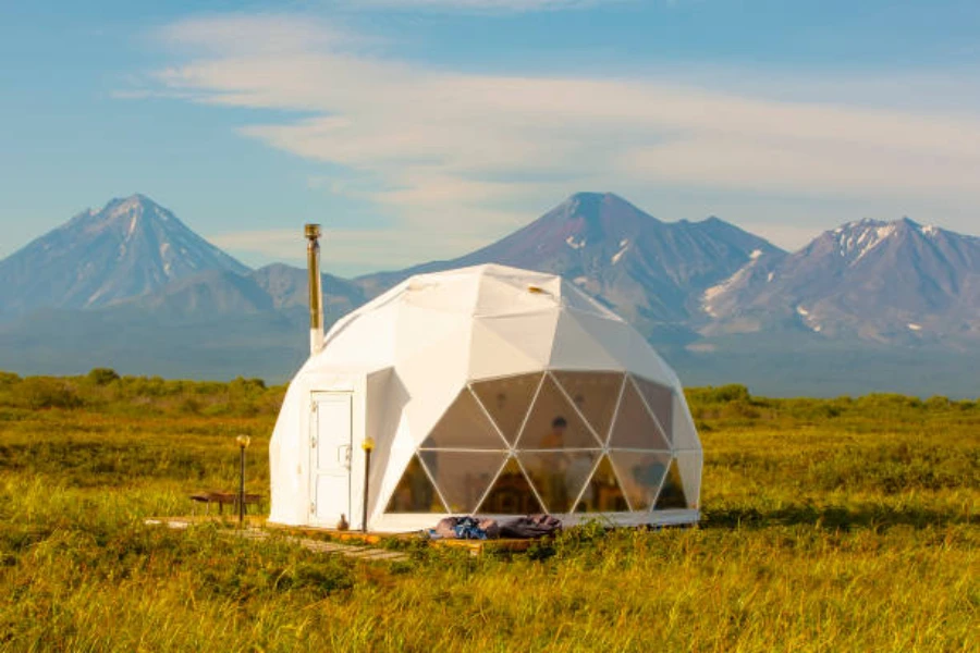 Geodesic yurt with glass panels in front of mountains