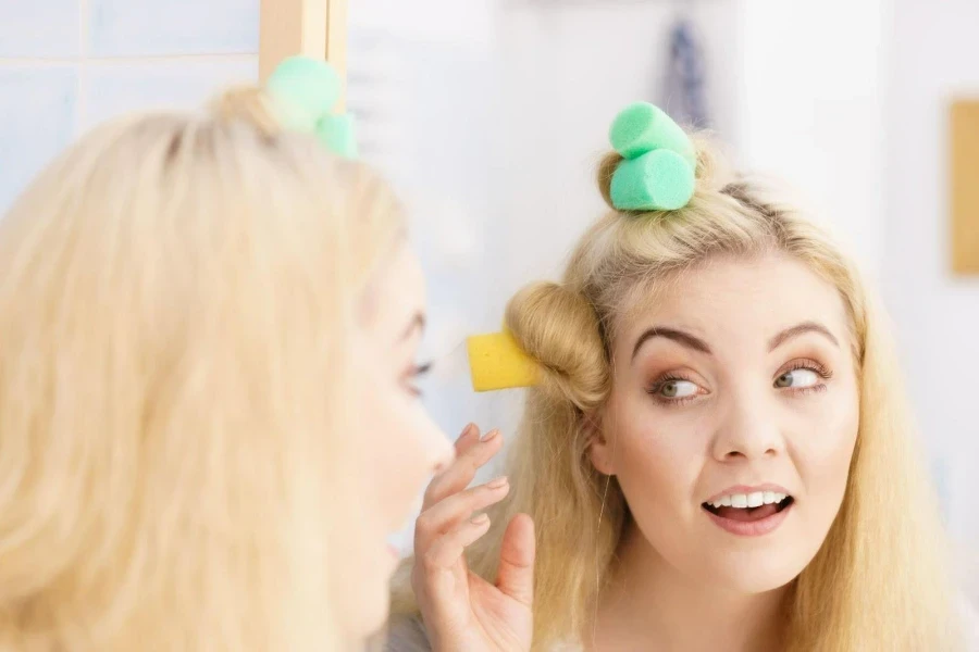 Lady setting sponge rollers in front of a mirror