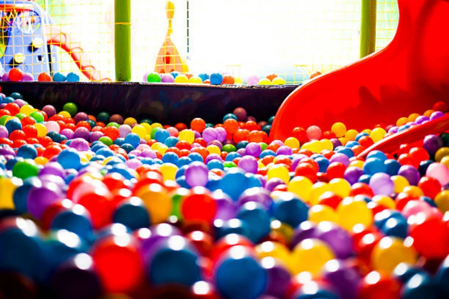 Large indoor ball pit with red slide going into it