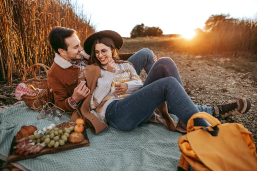 Man and woman sitting on a blanket in a corn field