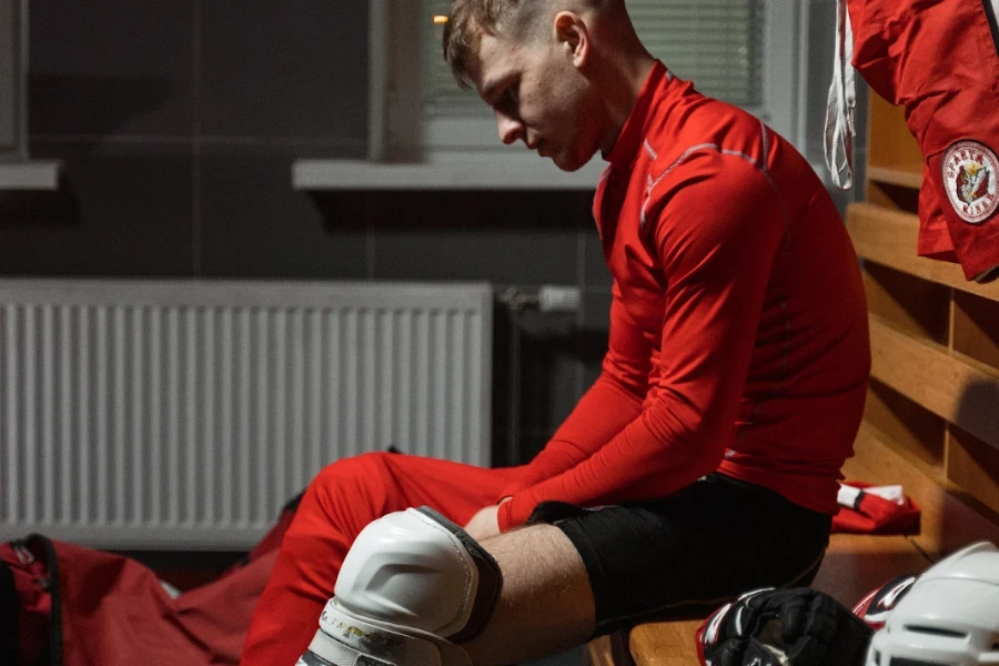 man in a locker room wearing large shin guards