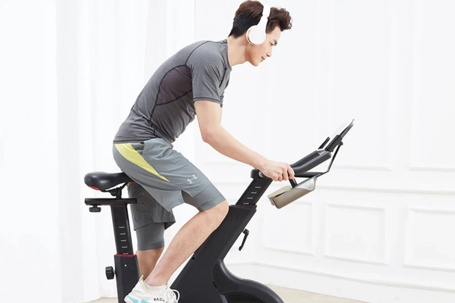 Man in gray shorts using stationary bikes