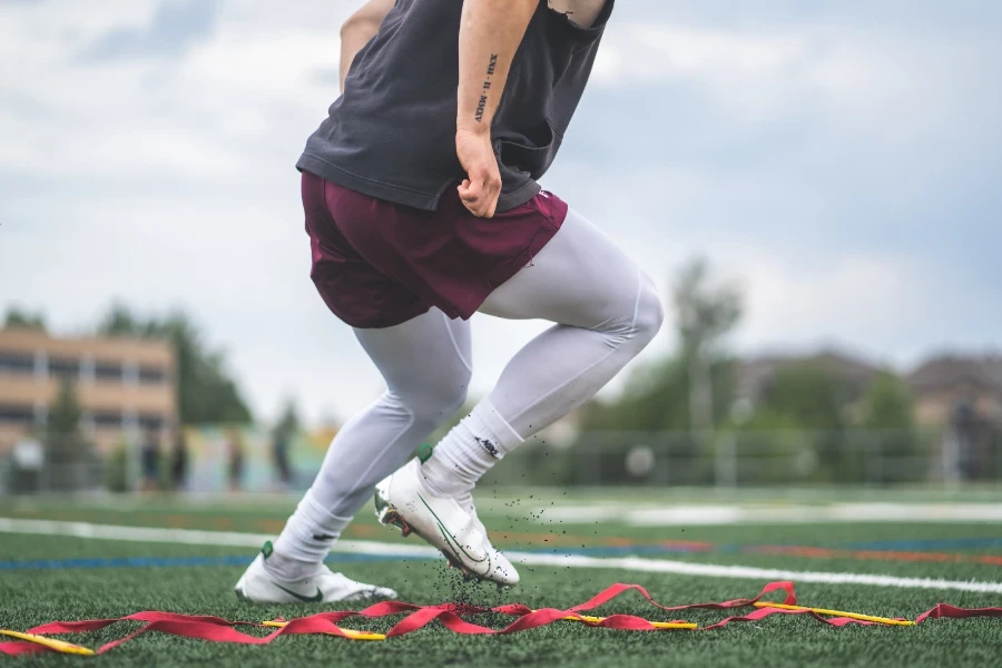 Uomo su un campo che indossa scarpe da calcio bianche