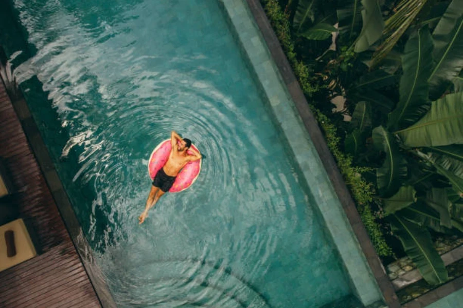 Man relaxing in donut swimming ring in a pool