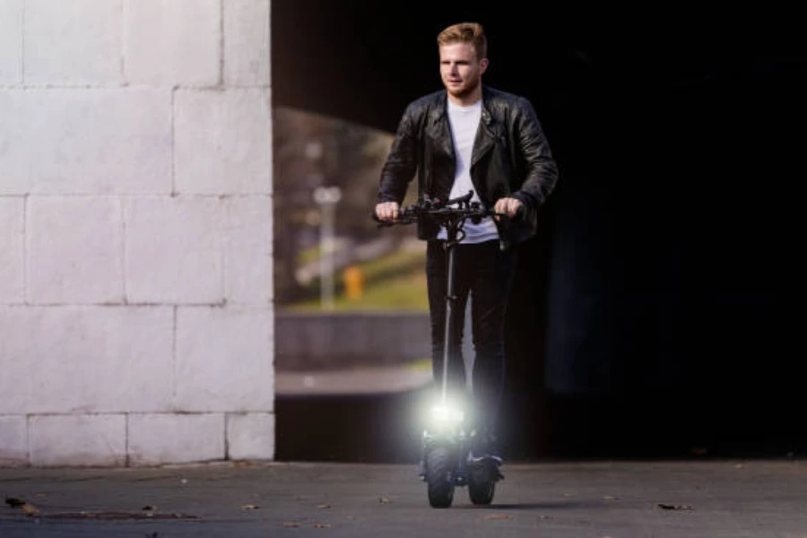 Hombre montando una scooter con una luz brillante en el frente