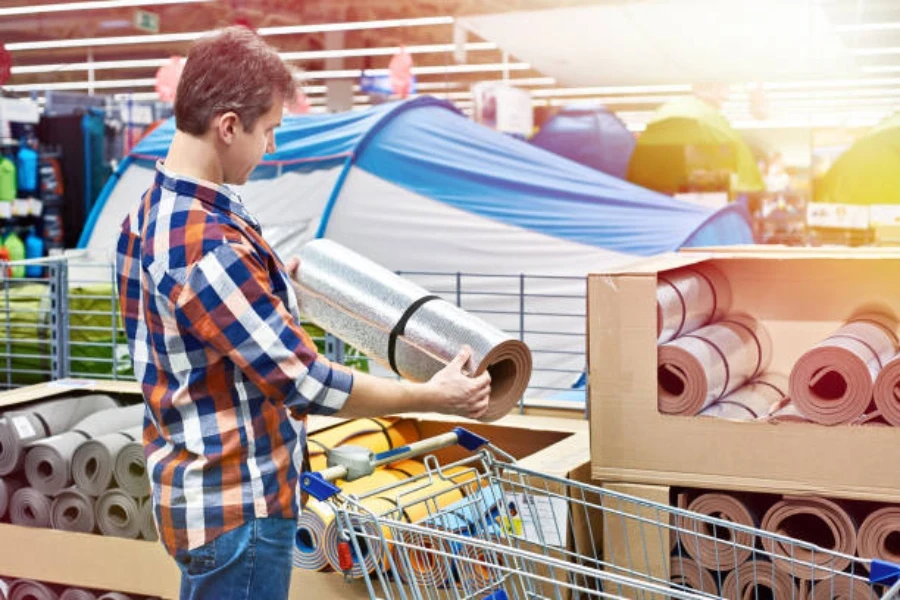 Homme shopping pour matelas de sol en mousse dans un magasin de sport