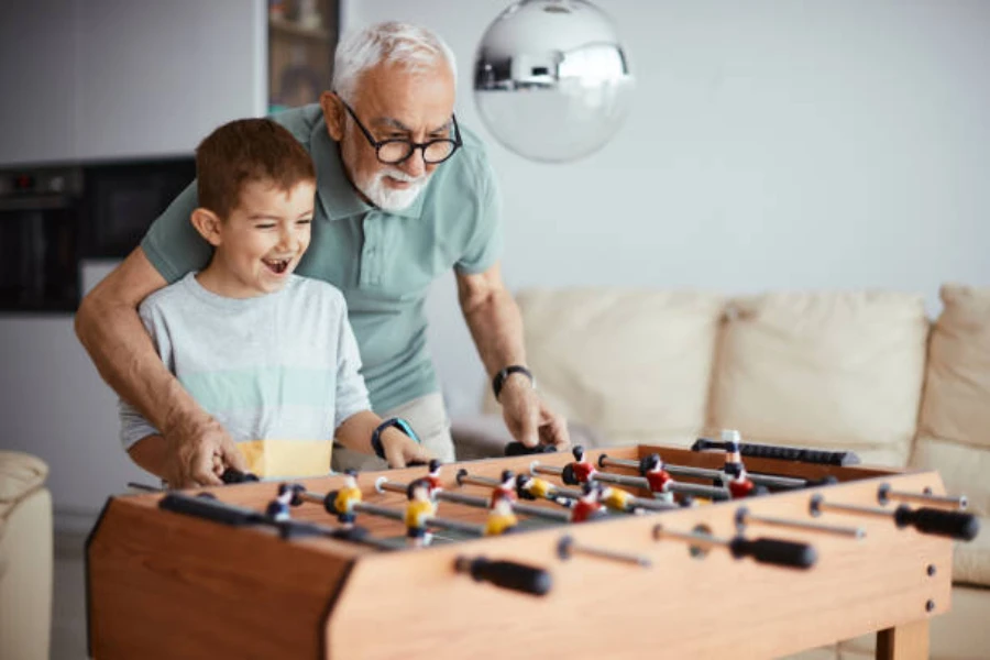 Man showing grandson how to play foosball