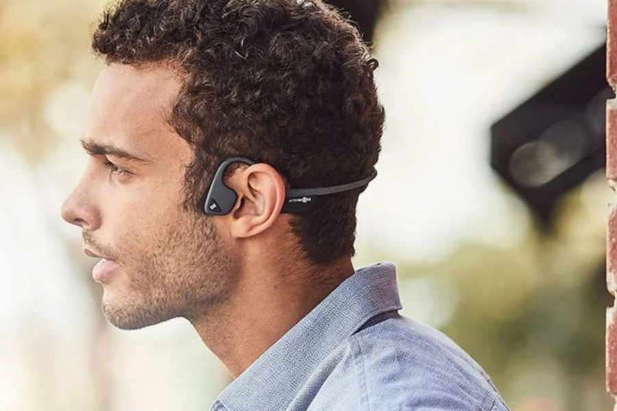 Man wearing black bone conduction earbuds