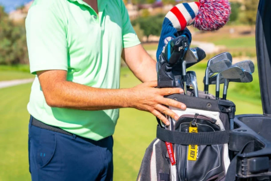 Man with cotton golf club head cover on driver